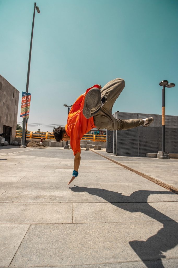 Parkour athlete mid-flip on an open city plaza