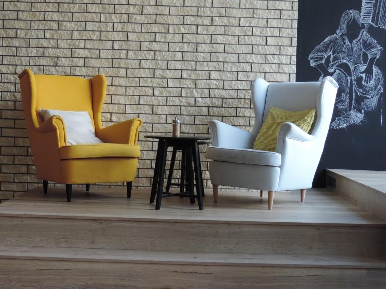 Two armchairs against a brick wall in a relaxed lounge corner
